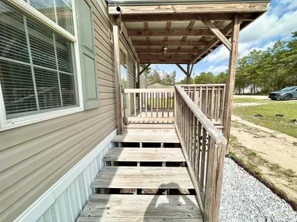 a view of balcony with wooden floor and fence