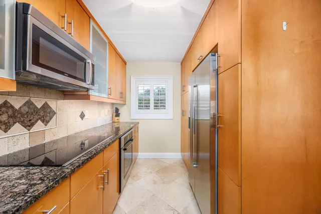 a kitchen with stainless steel appliances granite countertop a sink and a stove