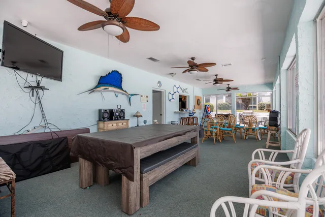 a bedroom with furniture a flat screen tv and a ceiling fan