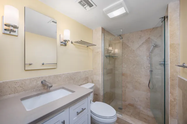 a bathroom with a sink a toilet and shower