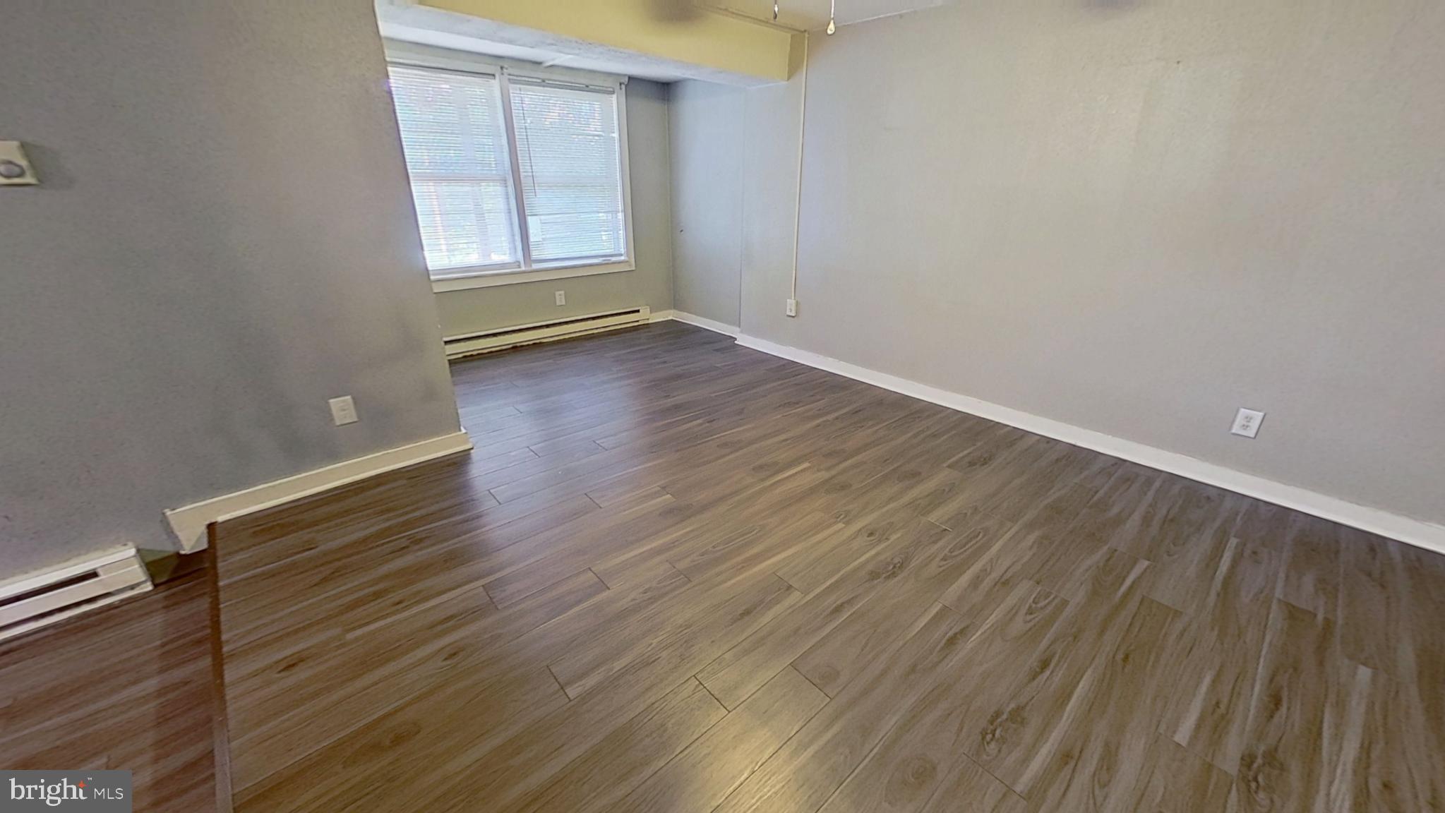 155 West Main Street, Unit 17 Windsor, PA 17366 - Photo 3 of 8 a view of an empty room with wooden floor and a window