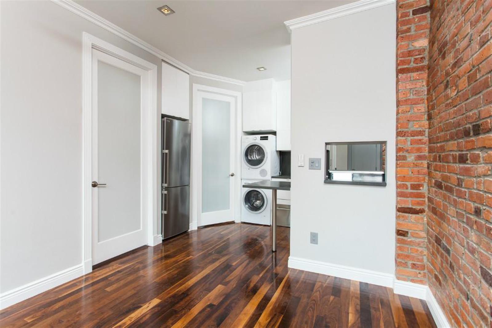 232 Elizabeth Street, Unit 5B Manhattan, NY 10012 - Photo 5 of 5 a view of a hallway with wooden floor and cabinets