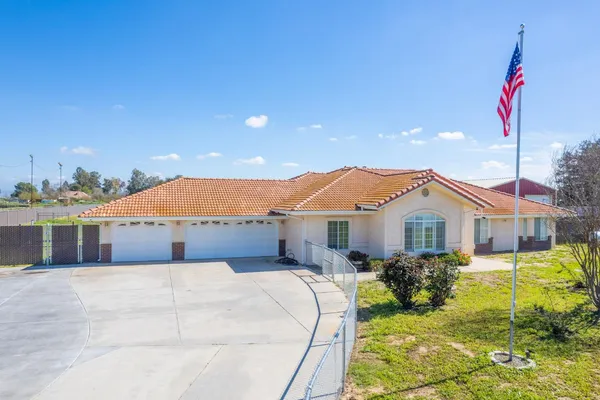 an empty room with wooden floor and ceiling fan