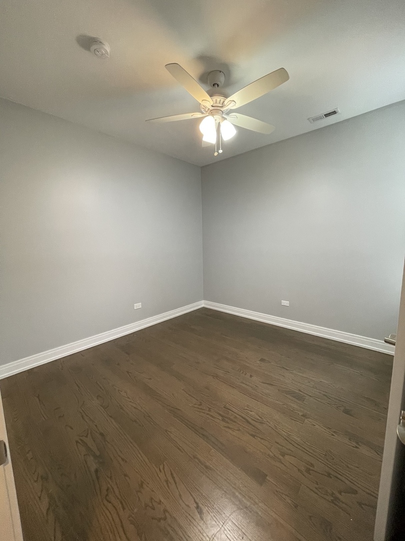 2036 West 18th Street, Unit 4 Chicago, IL 60608 - Photo 19 of 29 an empty room with wooden floor and fan
