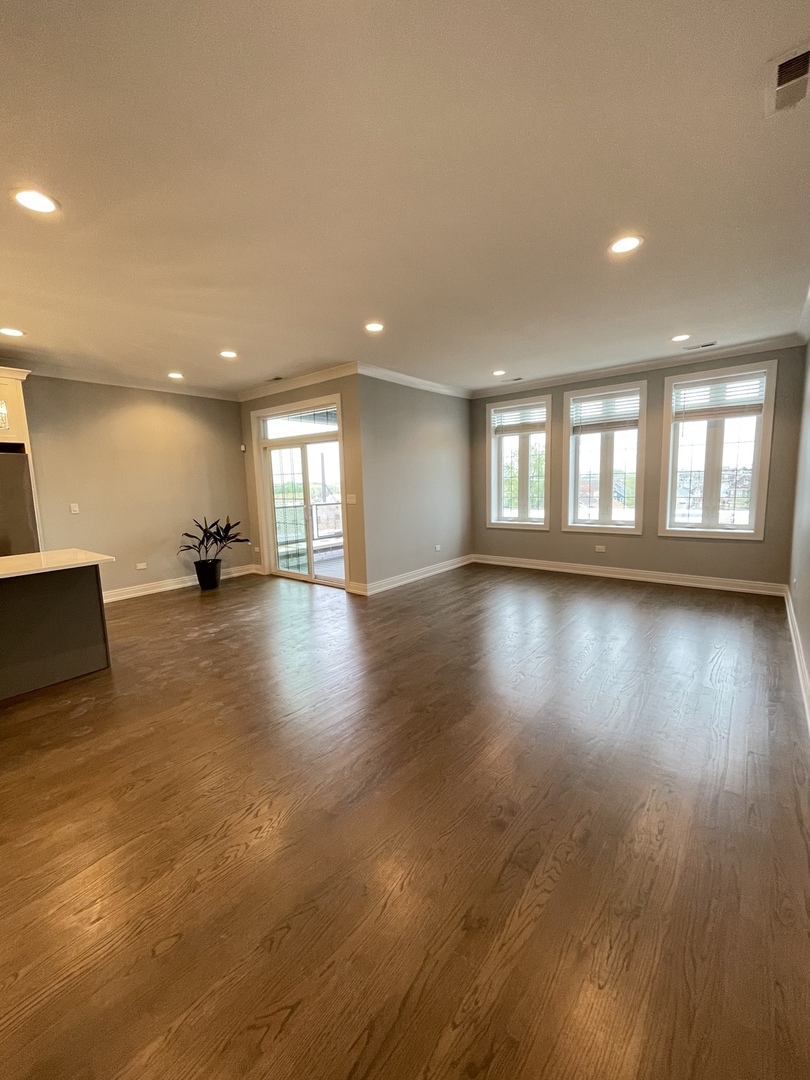 2036 West 18th Street, Unit 4 Chicago, IL 60608 - Photo 3 of 29 a view of an empty room with wooden floor and a window