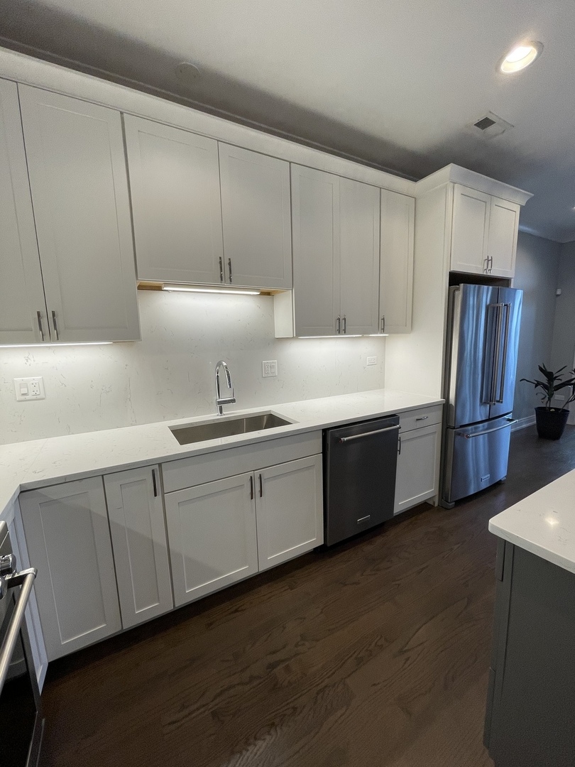 2036 West 18th Street, Unit 4 Chicago, IL 60608 - Photo 5 of 29 a kitchen with stainless steel appliances granite countertop a refrigerator a sink and white cabinets