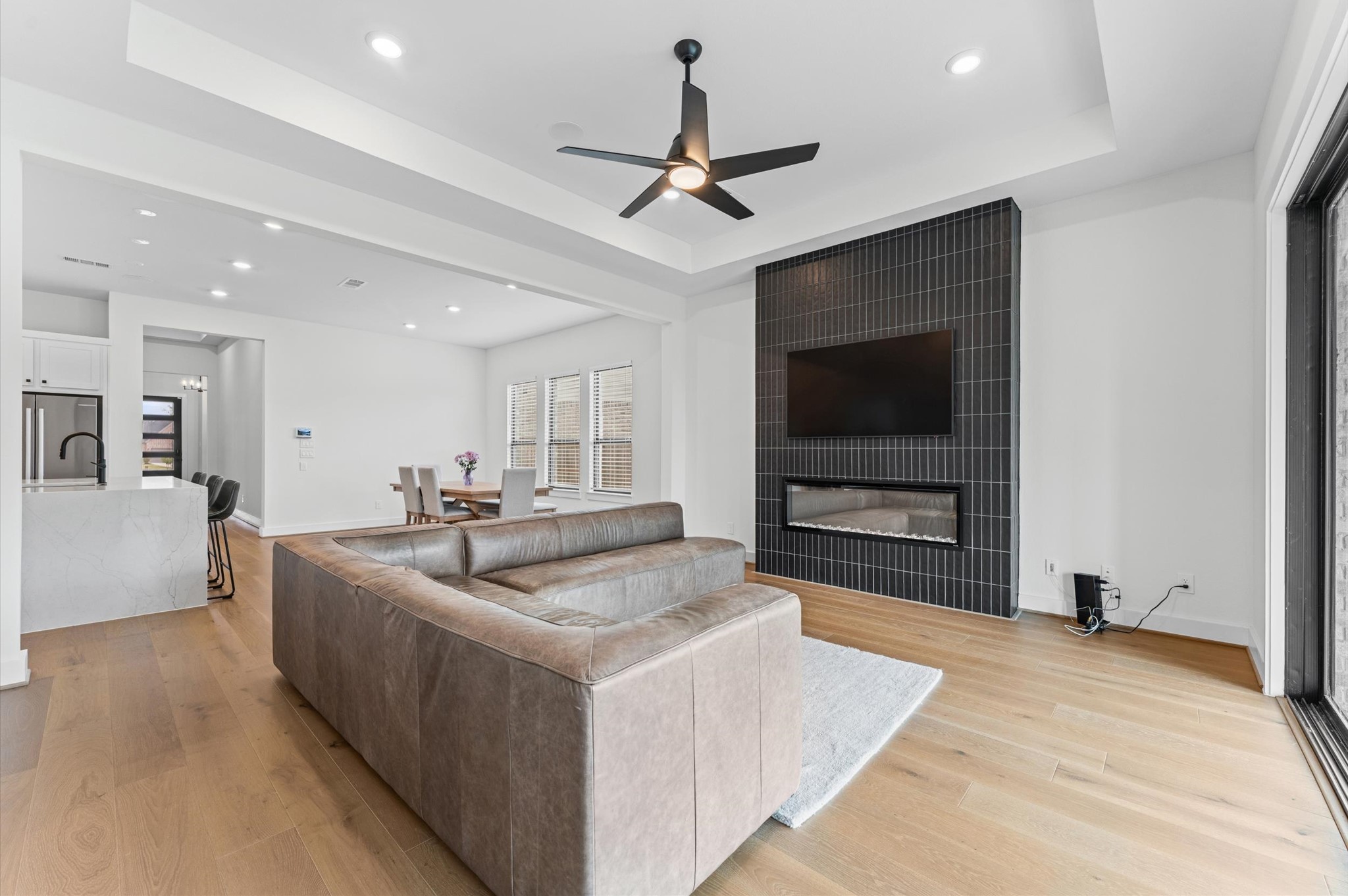 7327 Trial Rdg Drive Fulshear, TX 77441 - Photo 6 of 24 A warm focal point in the main living room — the fireplace with its modern dark surround adds character without trying too hard.