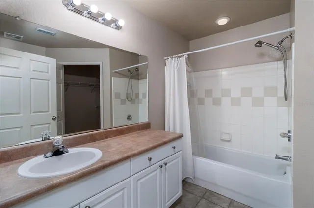 a bathroom with a granite countertop sink a mirror and a bathtub