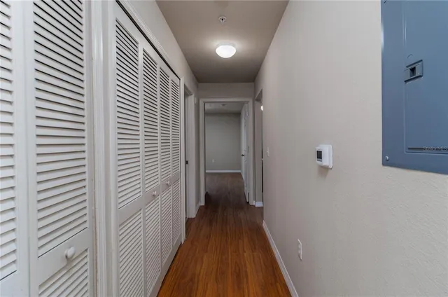 a view of a hallway with wooden floor and closet