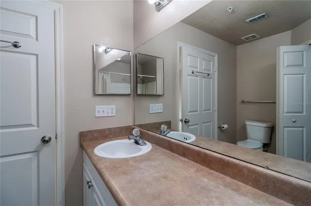 a bathroom with a granite countertop sink and a large mirror