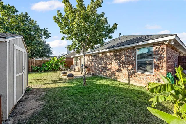 a view of backyard with small cabin and wooden fence
