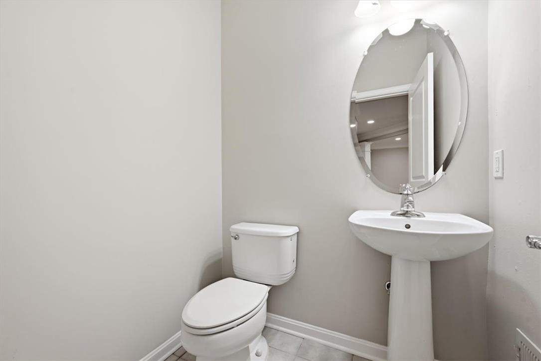 8761 Cascade Road Breinigsville, PA 18031 - Photo 49 of 84 A well-appointed powder room features a pedestal sink and an elegant oval mirror.