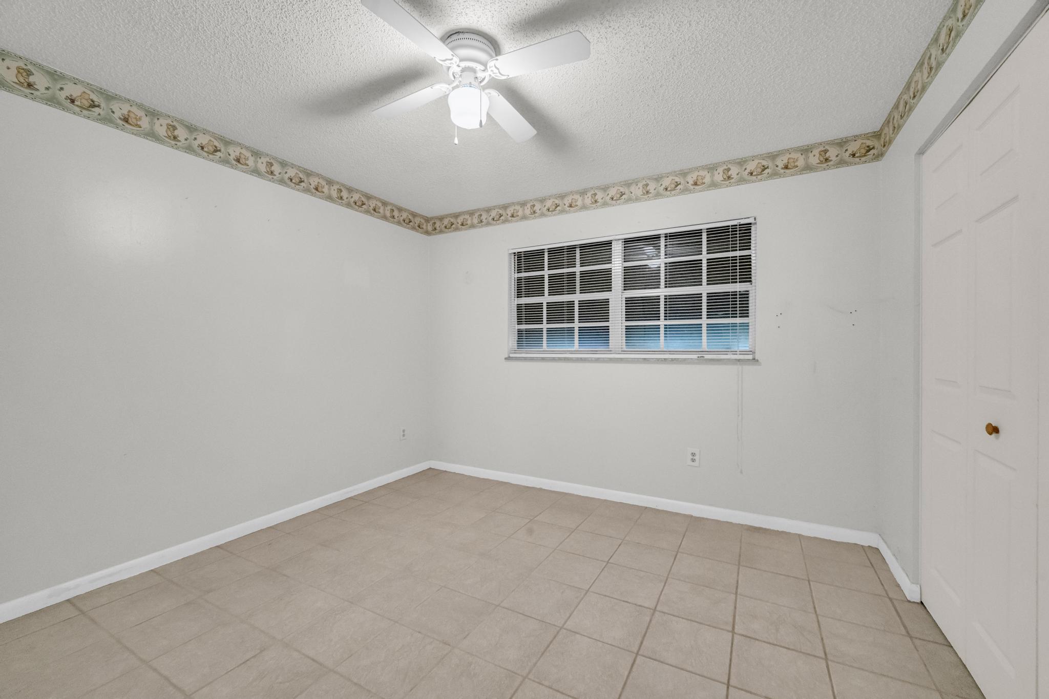 5406 Sunset Boulevard Fort Pierce, FL 34982 - Photo 13 of 33 an empty room with windows and fan