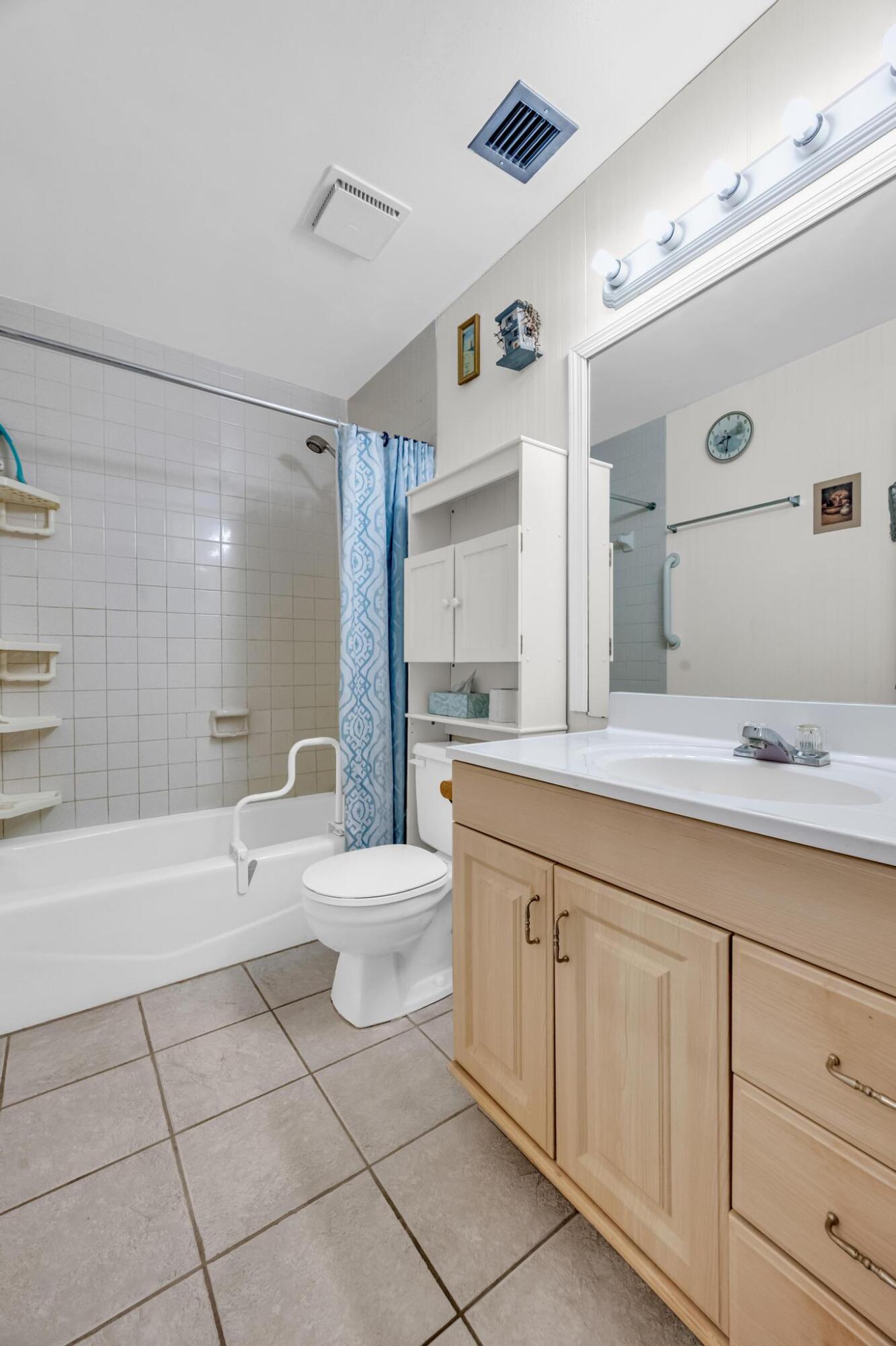 5406 Sunset Boulevard Fort Pierce, FL 34982 - Photo 15 of 33 a bathroom with a toilet a sink a mirror a bathtub and vanity