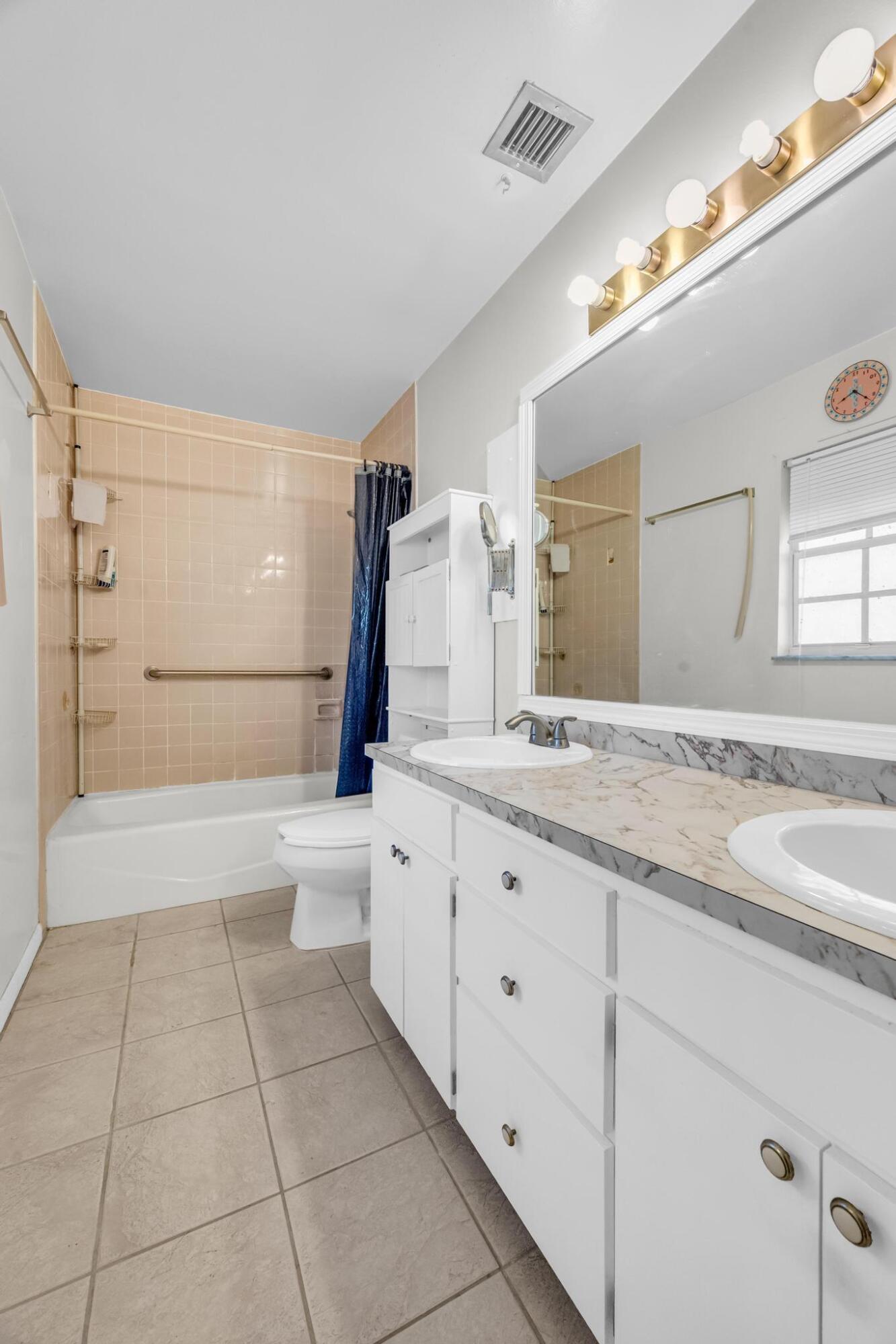 5406 Sunset Boulevard Fort Pierce, FL 34982 - Photo 20 of 33 a bathroom with a granite countertop sink a toilet and mirror