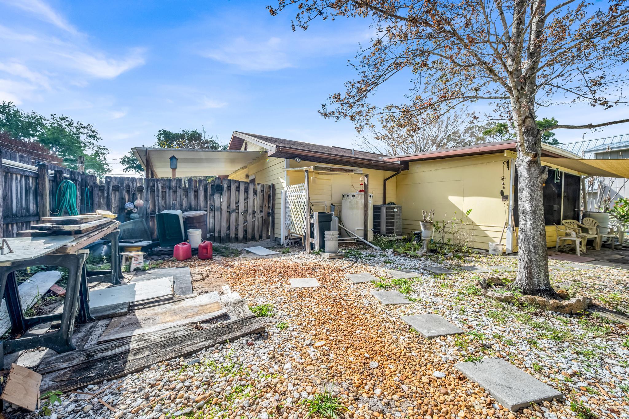 5406 Sunset Boulevard Fort Pierce, FL 34982 - Photo 29 of 33 a view of a patio with table and chairs a barbeque with wooden fence