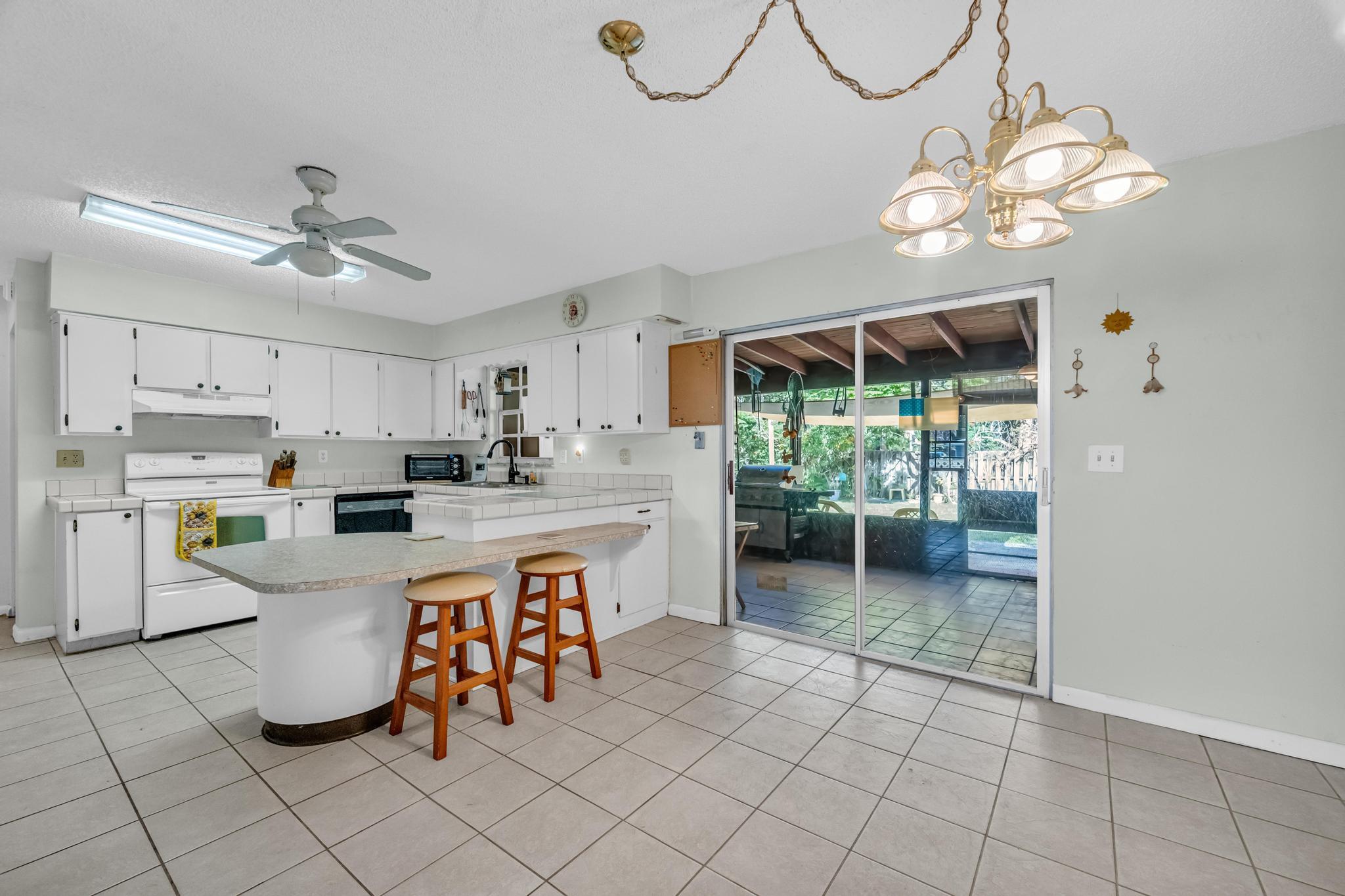 5406 Sunset Boulevard Fort Pierce, FL 34982 - Photo 4 of 33 a kitchen with kitchen island granite countertop cabinets a sink a stove and a dining table