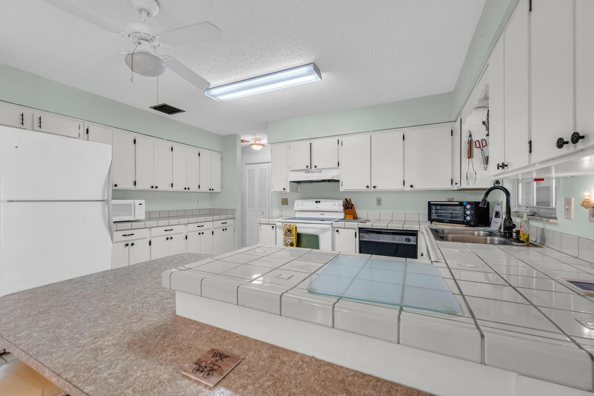 5406 Sunset Boulevard Fort Pierce, FL 34982 - Photo 6 of 33 a kitchen with cabinets and a stove top oven