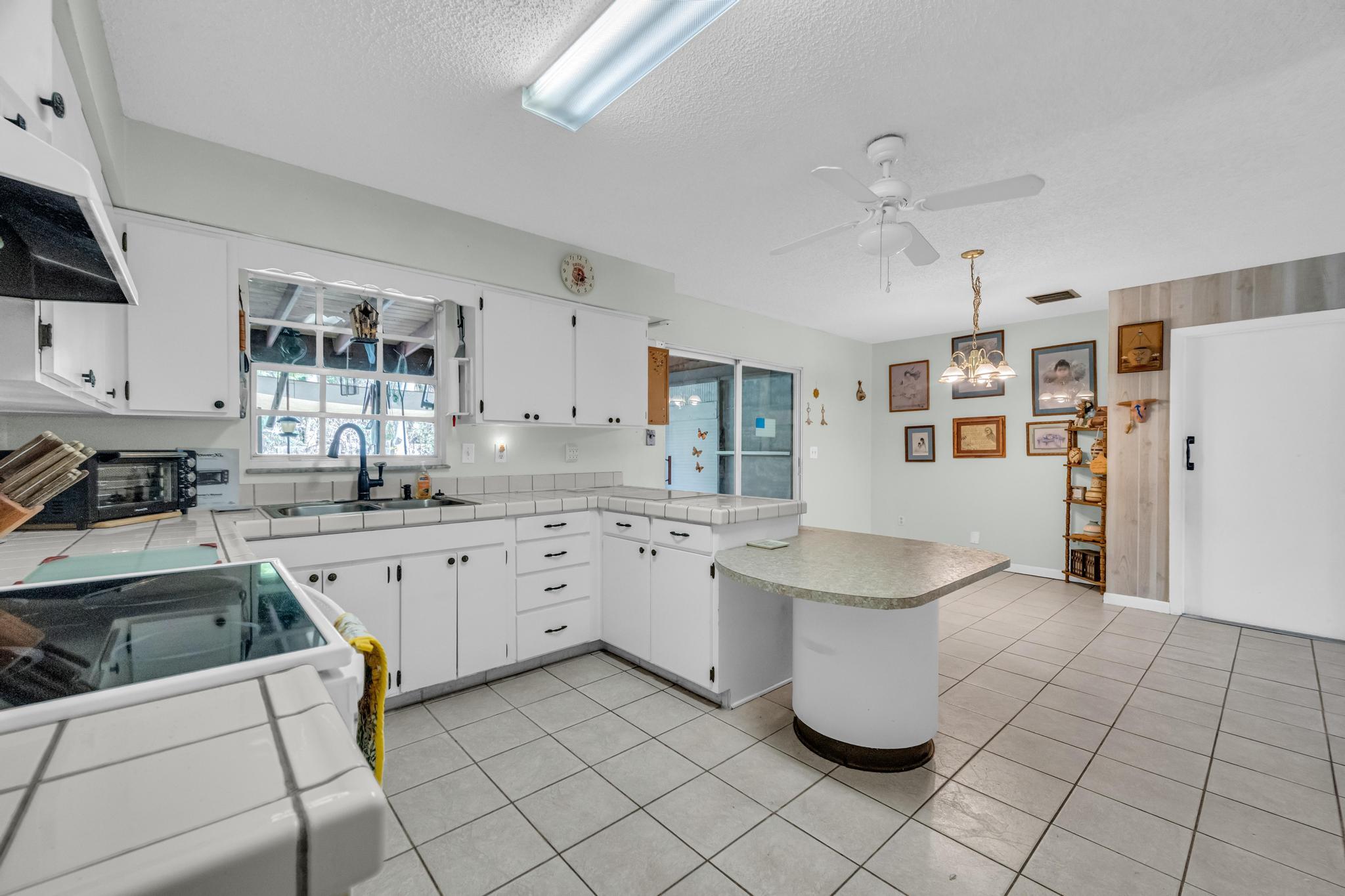 5406 Sunset Boulevard Fort Pierce, FL 34982 - Photo 9 of 33 a kitchen with cabinets and chairs