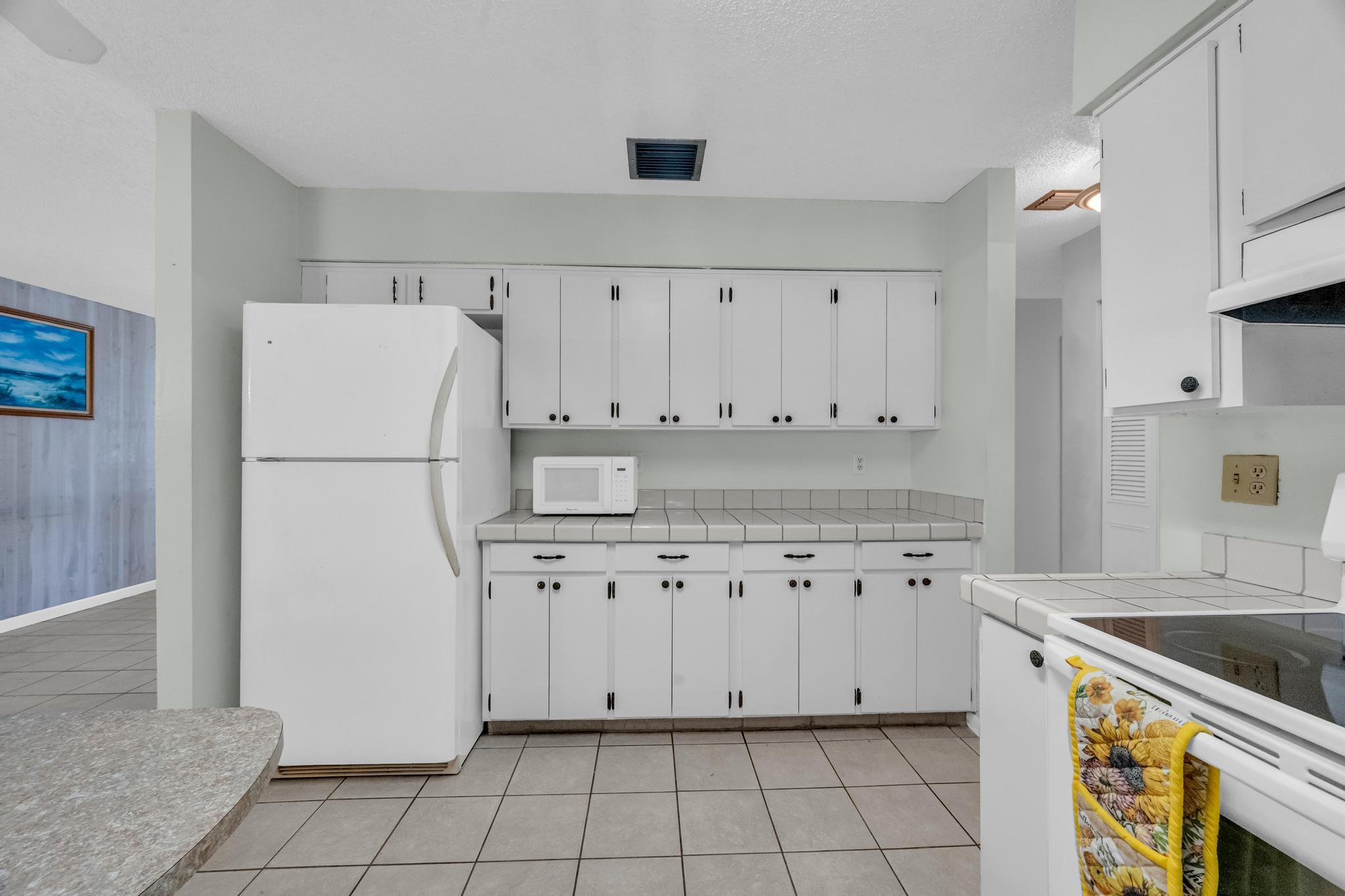 5406 Sunset Boulevard Fort Pierce, FL 34982 - Photo 10 of 33 a kitchen with granite countertop white cabinets and refrigerator