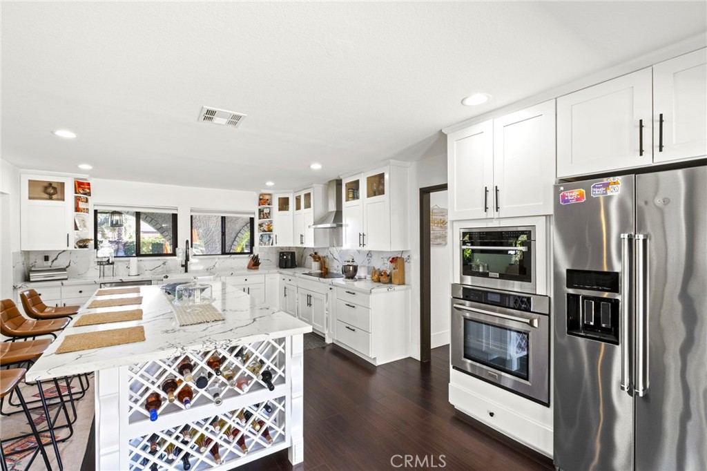 7710 Broadacre Place Riverside, CA 92504 - Photo 15 of 65 a kitchen with stainless steel appliances kitchen island granite countertop a refrigerator and cabinets