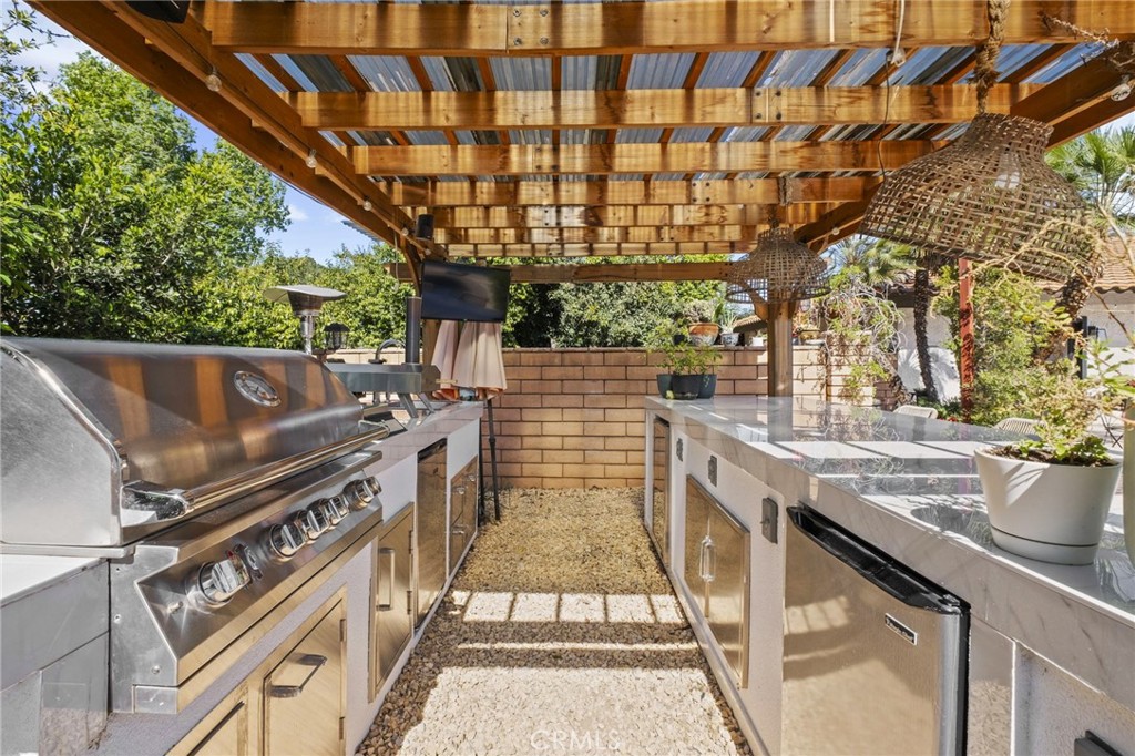 7710 Broadacre Place Riverside, CA 92504 - Photo 52 of 65 a view of a patio with table and chairs with wooden floor and fence