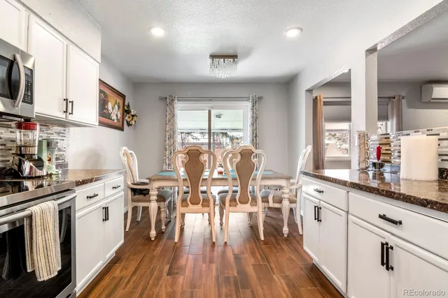 a kitchen with stainless steel appliances a white cabinets and wooden floors