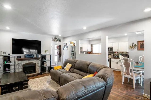 a living room with furniture a flat screen tv and a fireplace