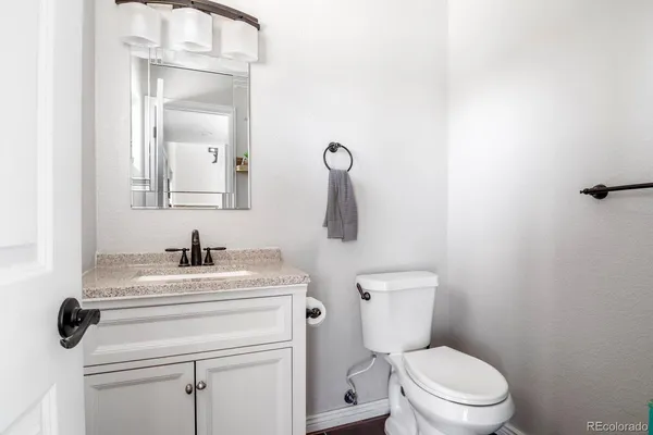 a bathroom with a toilet sink vanity and mirror