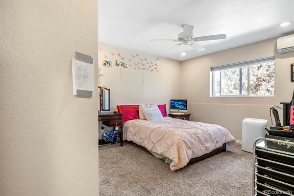 a bedroom with a bed a couch and a chandelier