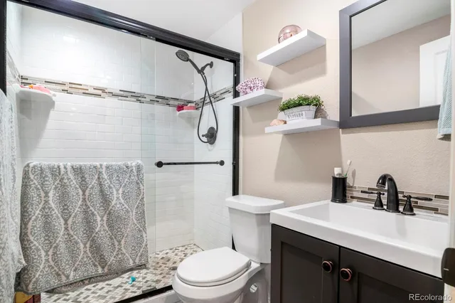 a bathroom with a sink a toilet and shower