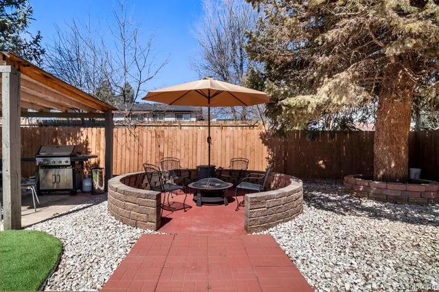 a backyard of a house with barbeque oven table and chairs
