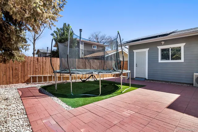 a view of backyard with table and chairs and wooden fence
