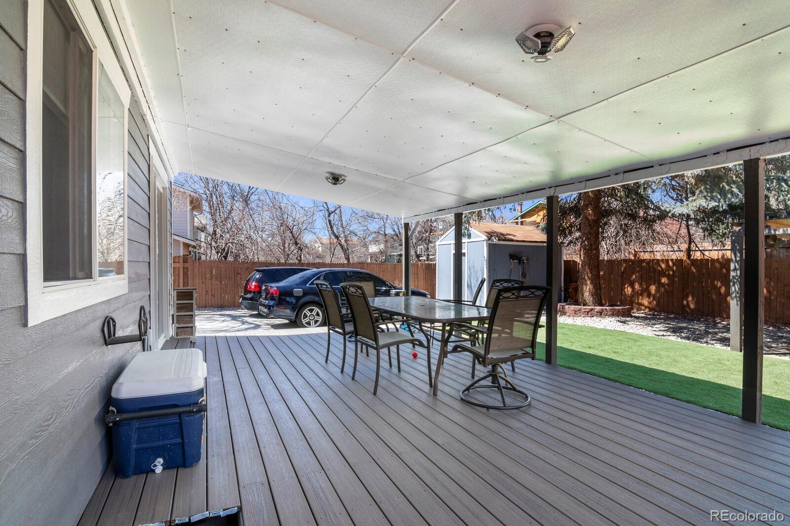 1065 Modred Street Lafayette, CO 80026 - Photo 10 of 34 a view of a patio with table and chairs potted plants with wooden floor