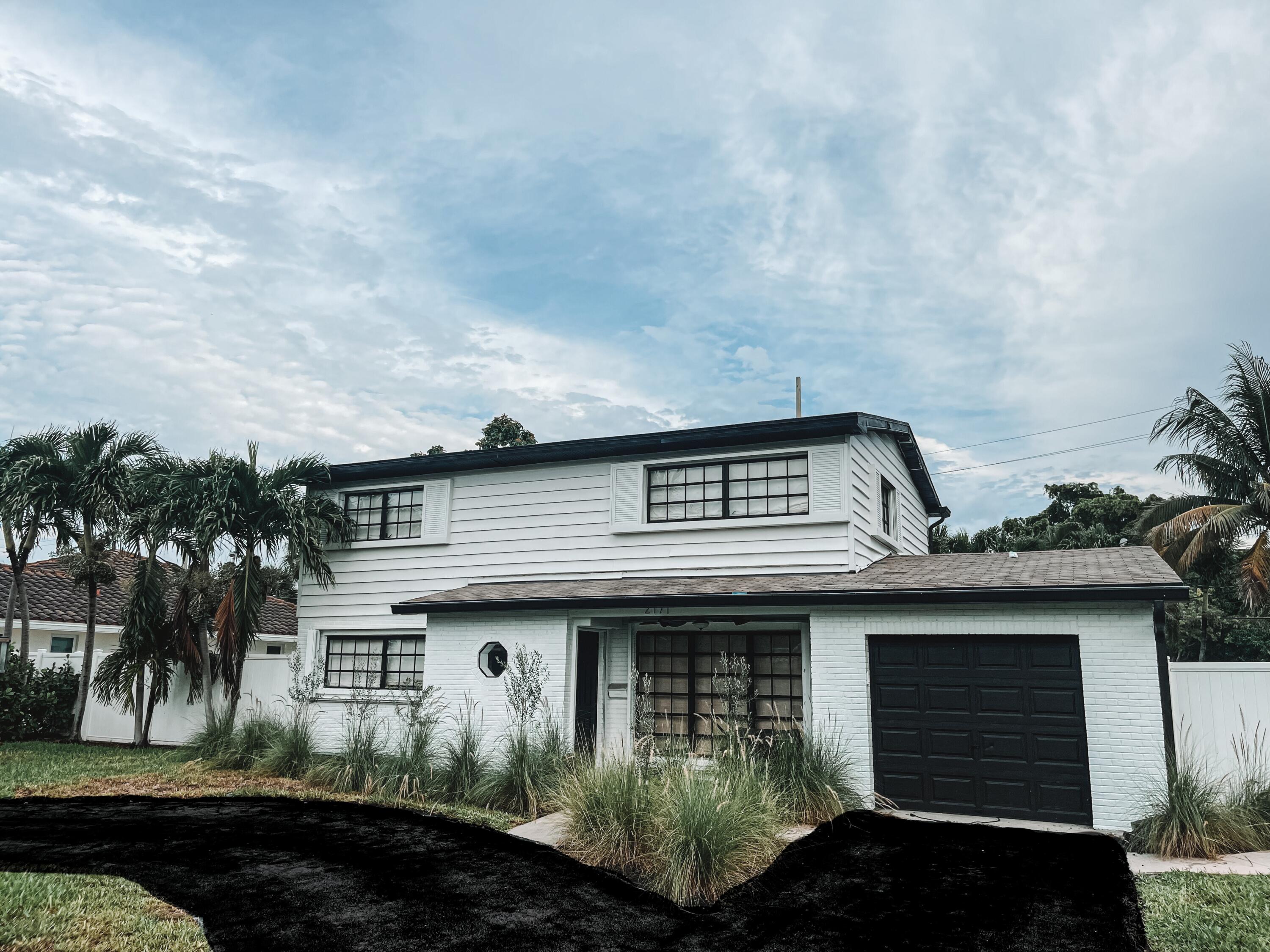 2171 Northeast 44th Court Lighthouse Point, FL 33064 - Photo 1 of 24 a front view of a house with a garden