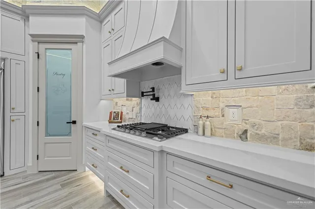 a kitchen with white cabinets and appliances