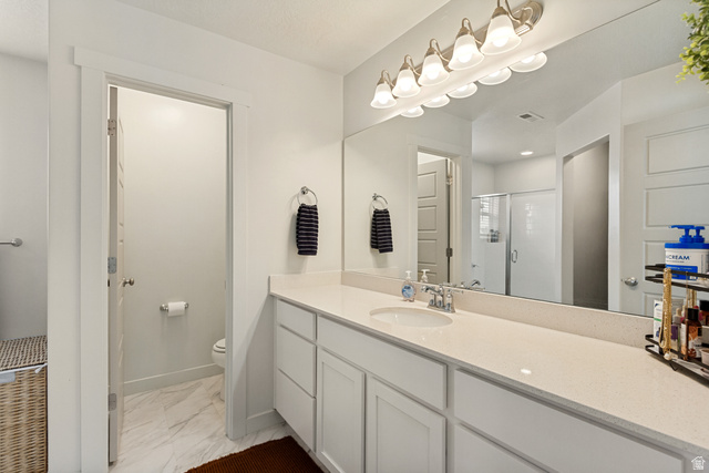 7693 West Mount Elinor Road Magna, UT 84044 - Photo 16 of 33 Long vanity with an integrated sink, broad wall-mounted mirror, and overhead lighting fixture