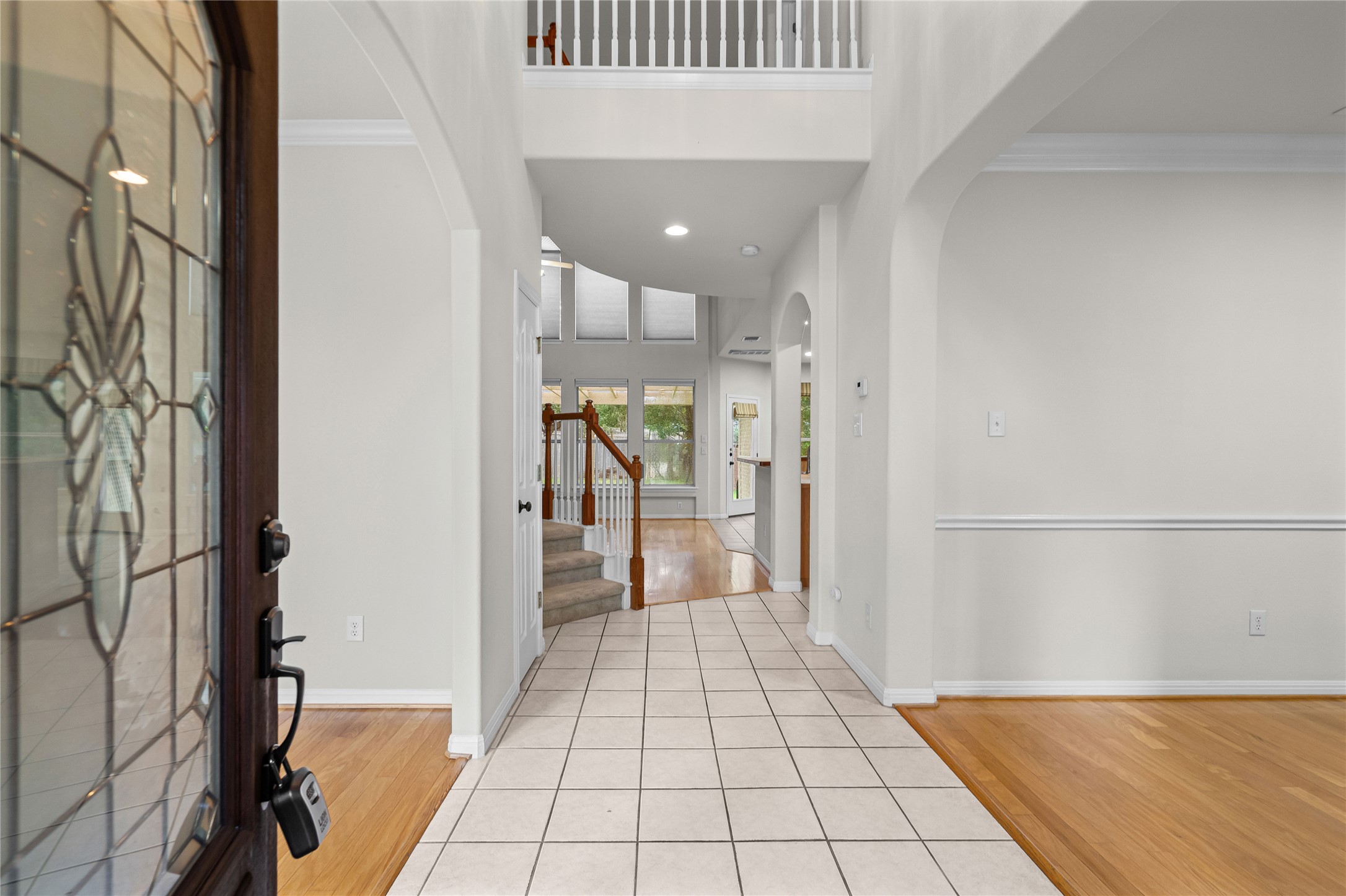 10700 Pointe View Drive Austin, TX 78738 - Photo 5 of 35 A grand entrance welcomes with gleaming hardwood and tile flooring, leading to a gracefully winding staircase.
