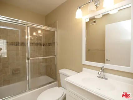 a bathroom with a sink shower and a mirror