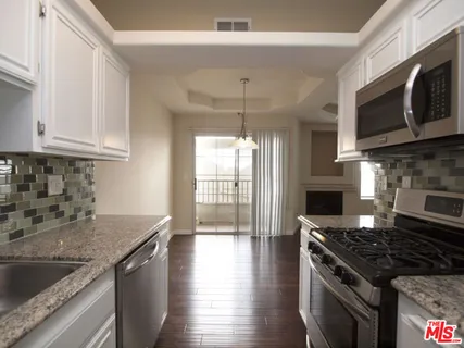 a kitchen with stainless steel appliances granite countertop a sink stove and microwave