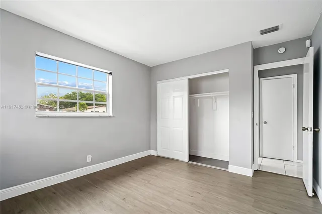 a view of empty room with wooden floor