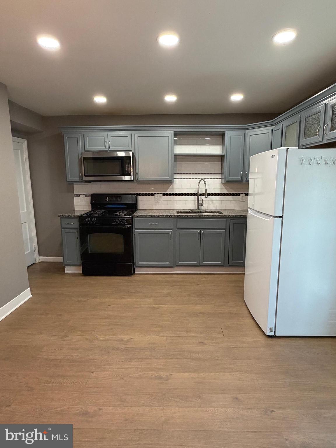 1353 Cambria Street Baltimore, MD 21225 - Photo 7 of 23 a kitchen with stainless steel appliances granite countertop a refrigerator and a stove top oven