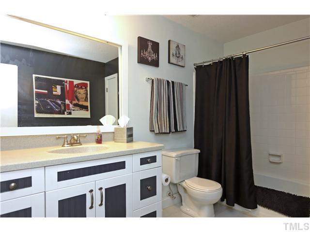 6413 Rushingbrook Drive Raleigh, NC 27612 - Photo 13 of 24 a bathroom with a sink a toilet a shower and a mirror
