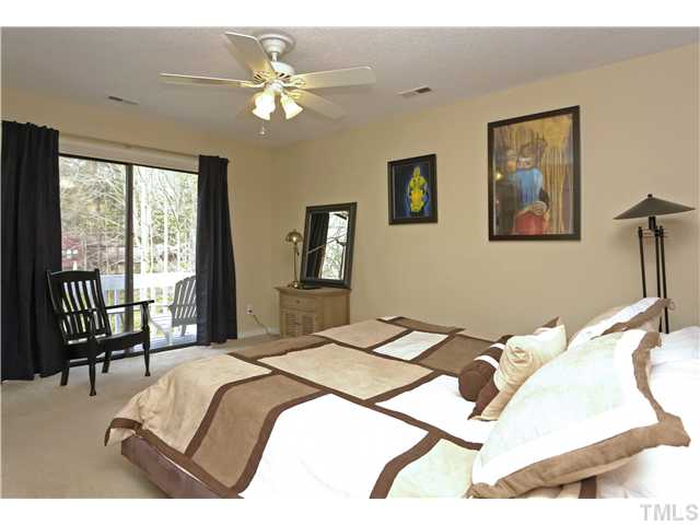 6413 Rushingbrook Drive Raleigh, NC 27612 - Photo 10 of 24 a bedroom with a bed painting on wall and a large window