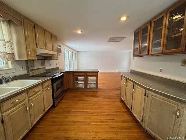 a large kitchen with stainless steel appliances granite countertop a stove and a sink