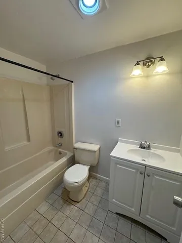 a view of an empty room with wooden floor and window