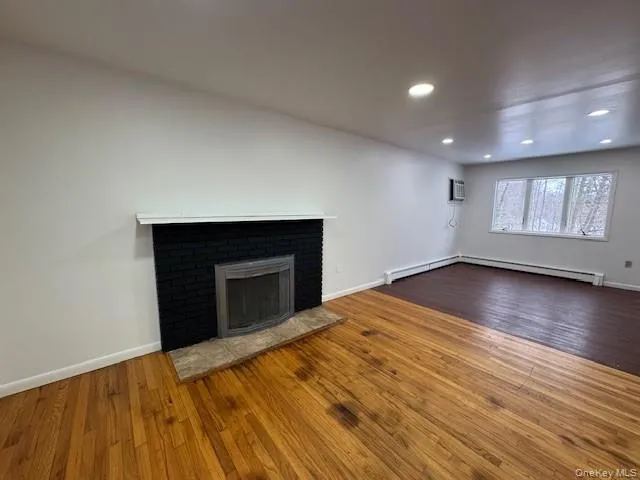 an empty room with wooden floor and fireplace