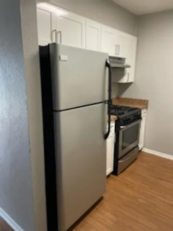 a white refrigerator freezer and a stove sitting inside of a kitchen