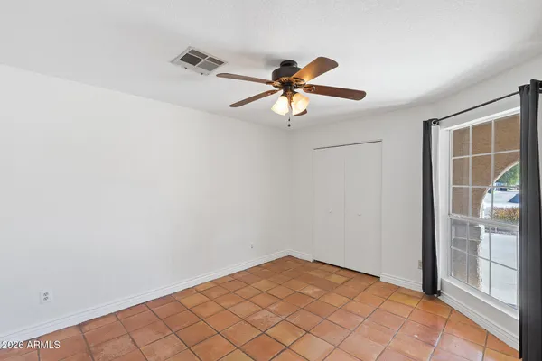 a view of empty room with wooden floor and fan