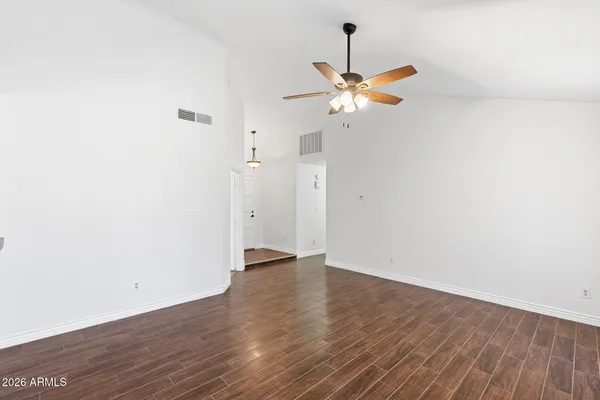 a view of a room with wooden floor and ceiling fan